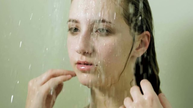 Young beautiful woman taking a shower in a bathroom. Slow motion. HD