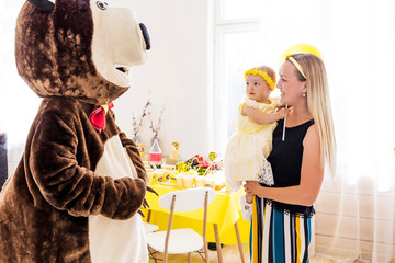 Actor in a bear costume congratulates a girl and her family on her birthday