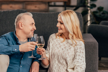 happy couple clinking glasses of wine at home