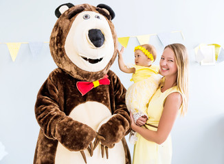 Actor in a bear costume congratulates a girl and her family on her birthday