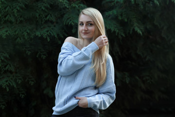 Beautiful young girl, blonde with long hair on the background of green.