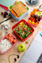 Top view shot with healthy lunch dishes variety: salad with grains, salmon and rice, sandwich and...