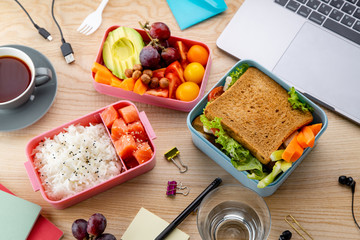 Flat lay with healthy lunch dishes variety: sandwich, salad and fruit snacks. Daily office or school lunch concept