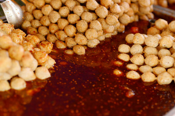 Fried meatballs in dipping sauce or chili paste. Selective focus.