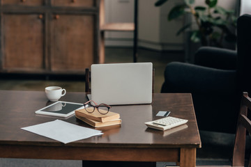 gadgets near cup, books and calculator on desk