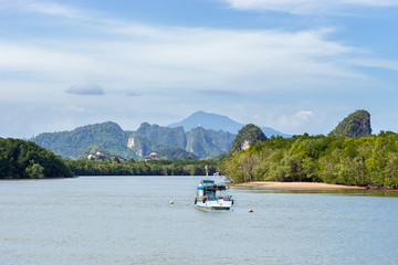 Landscape of a local boat in Khao Khanab Nam river water with beautiful mountains on background in Krabi Town in Thailand