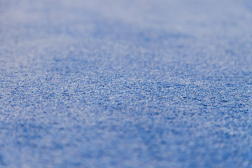 Blue artificial fabric texture carpet covering. Selective focus with blur. Wallpaper, pattern.