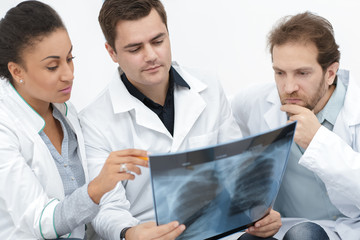 Obraz premium Group of diverse doctors discussing x-ray of the patient