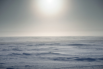 Winter landscape. The surface of the frozen sea. A little fog