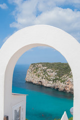 Fototapeta na wymiar Cape of En Porter with turquoise sea seen through an arch of a typical white house
