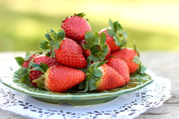 strawberries on green plate and light background.