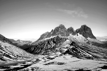 Beautiful artistic, unusual/ uncommon snowy landscape. Mountains in Black and White. Alps (Trentino, Italy) in a beautiful morning. Travelling alone in the wilderness. The snow during the spring thaw.