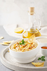 Hummus served with chips, chickpeas, parsley and paprika.