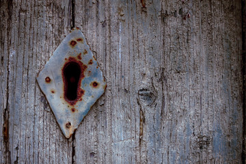 hole in an old lock with a diamond plate on a wooden background