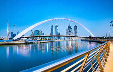 Obraz premium colorful sunset over Dubai Downtown skyscrapers and the newly built Tolerance bridge as viewed from the Dubai water canal