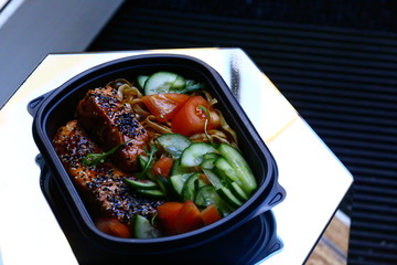 Sesame salmon with teriyaki sauce, noodles and vegetables in bowl