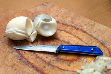 Boiled eggs and a knife on the cutting Board in the kitchen