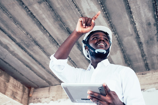 African engineer man architect looking and holding construction project on tablet