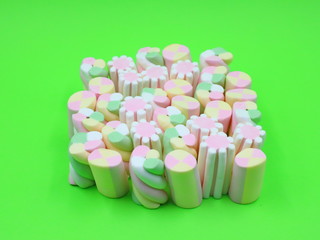 Colorful Marshmallows on green background