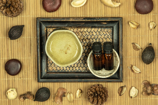 Aroma lamp with essential oil and potpourri on wooden bamboo mat background.