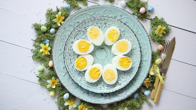 Easter table setting with flowers and eggs. Decorative plates with boiled eggs