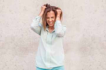Young woman standing isolated on wall crying desperate