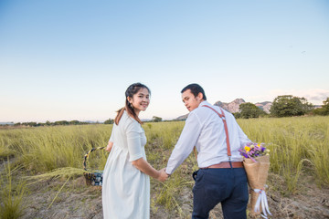 Couple of love running together in green field