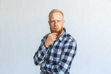 Obraz premium Freestyle. Mature man standing isolated on grey scratching beard thinking