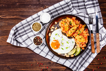 Grilled chicken meat with groats and fried egg on wooden table