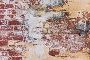 Texture Of Old Brick Wall With Yellow Plaster. Texture Of Old Ruined Wall Of Old Abandoned House.