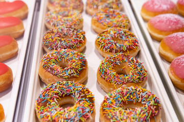 Doughnuts Or Donuts With Chocolate Icing Or Glaze And Sprinkles On Counter Confectionery. Sweets For Romantic Date, Close-up, Selective Focus.