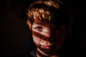 Portrait of a young boy in shadows