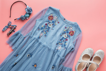Girls' fashion background, blue tulle dress with embroidery, sparkly shoes, flower headband,...