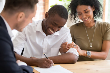 Happy african family couple customers sign mortgage loan insurance contract