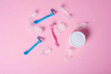 razor, white feather, jar cream soft beauty on pink background, top view