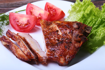 grilled pork chops with tomato, leaves lettuce and ketchup on plate.