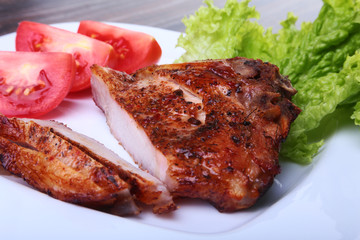 grilled pork chops with tomato, leaves lettuce and ketchup on plate.
