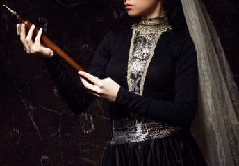 Young woman in armenian national dress with national musical instrument duduk in hands