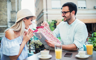 Shopping time. Young couple resting in the cafe after shopping. Consumerism, lifestyle concept