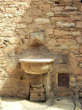 Fontanella medievale in marmo con gargolla