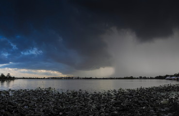 Lake view of dark clouds moving in strong wind with rain storm above the lake, Krajub reservoir in Banpong District, Ratchaburi, Thailand.