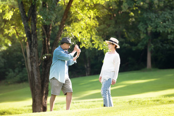 Image of happy romantic Asian senior couple outdoor in park