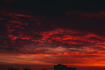 Fiery red blood vampire dawn. Amazing warm dramatic fire cloudy sky. Vivid orange sunlight....