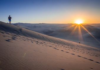 silhouette of man in desert at sunset