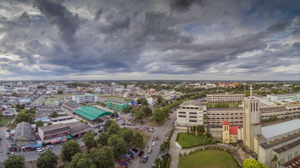 Aerial view above city and christ church of dark clouds moving with rain storm background, Ban Pong City, Ratchaburi, Thailand.