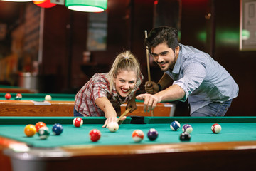 billiard- smiling couple shooting pool ball  .