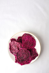 Purple dried dragon fruit on white plate on isolated on white background for graphic purpose with empty text copy space