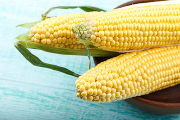 Fresh corn on cobs on wooden table, closeup