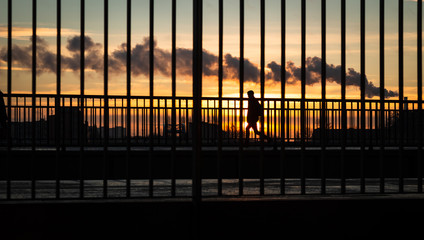 people at sunset behind a metall fence