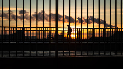 people at sunset behind a metall fence